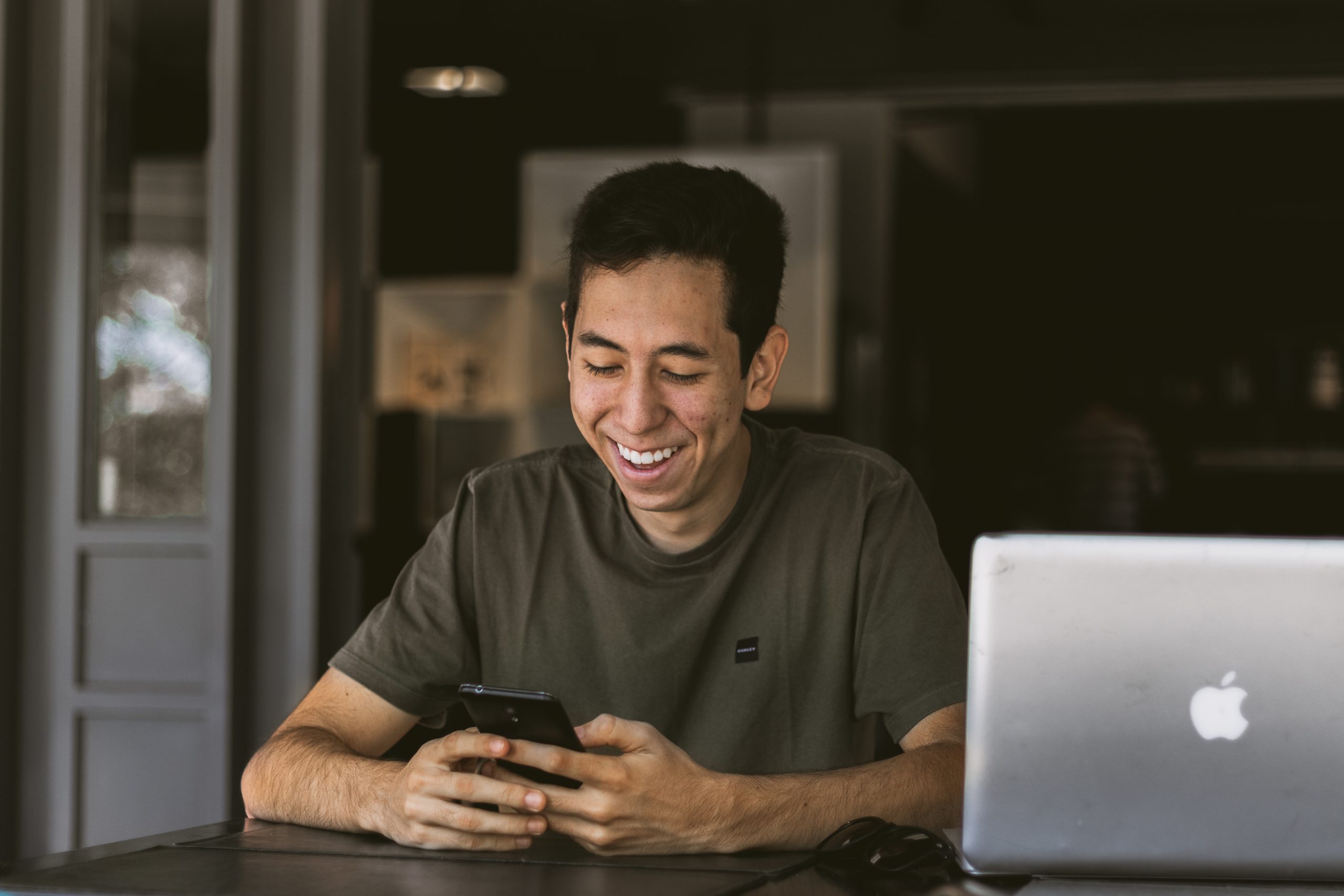 man smiling while looking at phone